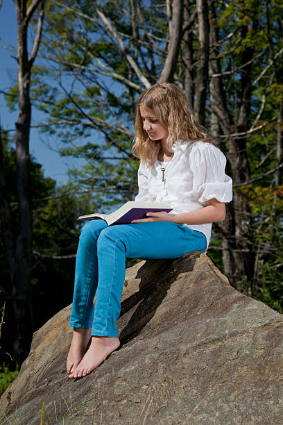 istock Girl reading a book outside 183036194