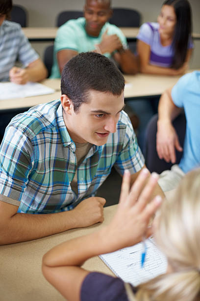 istock Happy young student studying with his friends in classroom 183036408