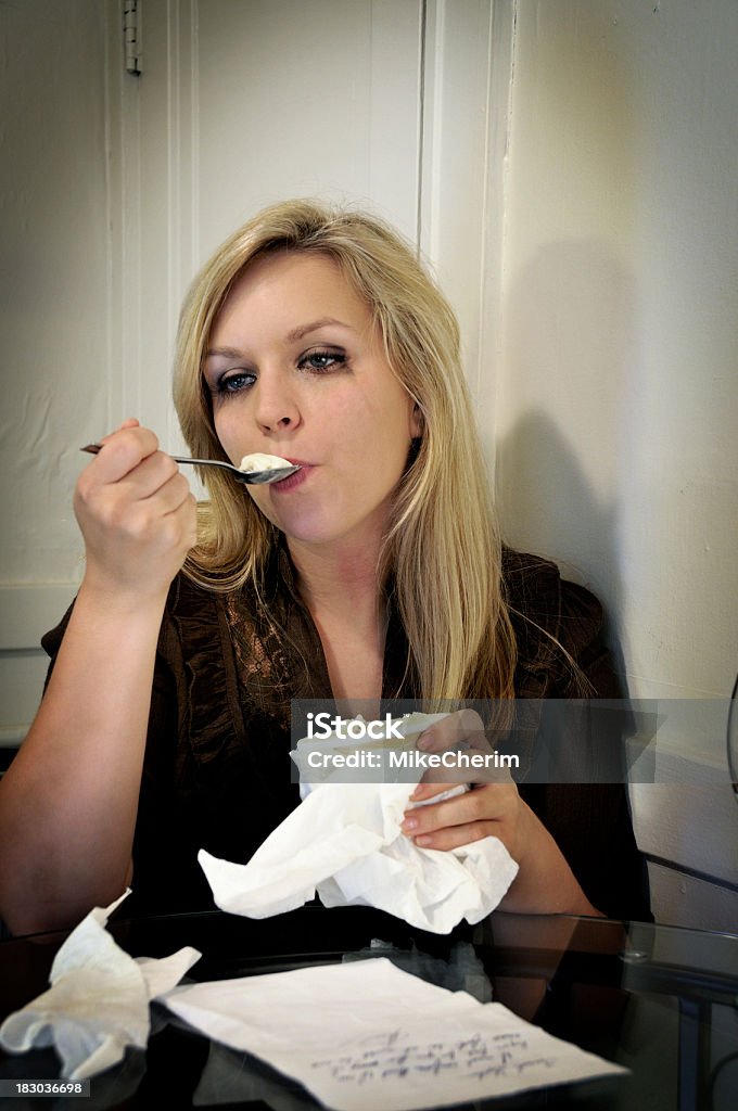Sad Woman Drowns Sorrows in Ice Cream "Woman gets a bad news letter and after having read it consoles herself with ice cream right from the quart. Letter could be a break-up letter or may be useful for any bad news: loss of loved one, even a demand (with a little PS work), etc." Contemplation Stock Photo