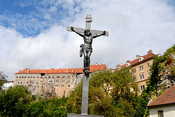 Iron crucifix in front of medieval castle