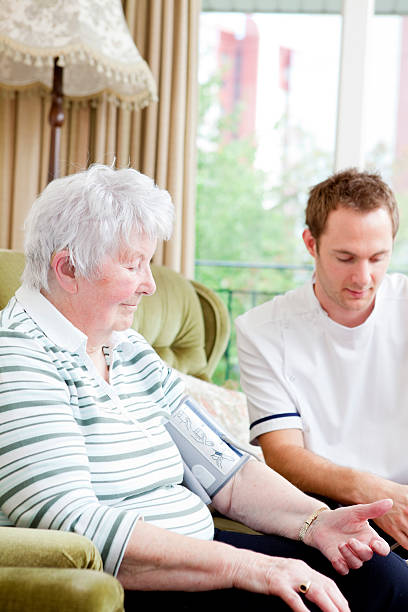 Nurse checking senior ladys blood pressure