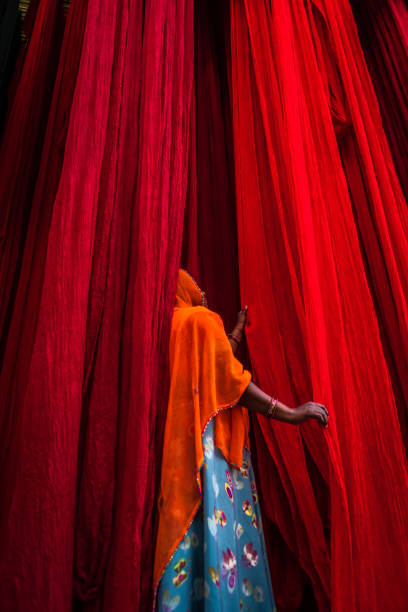 Colors of India - woman checking dyed fabrics, Rajasthan, India Indian woman checking freshly dyed fabric hanging to dry, sari factory, Rajasthan, India, Asia india indigenous culture indian culture women stock pictures, royalty-free photos & images