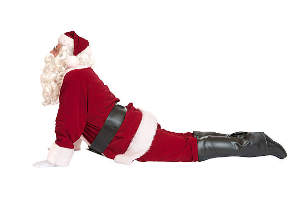 Santa in an upward facing dog yoga position, de-stressing in preparation for the hectic season ahead.  Isolated on white.