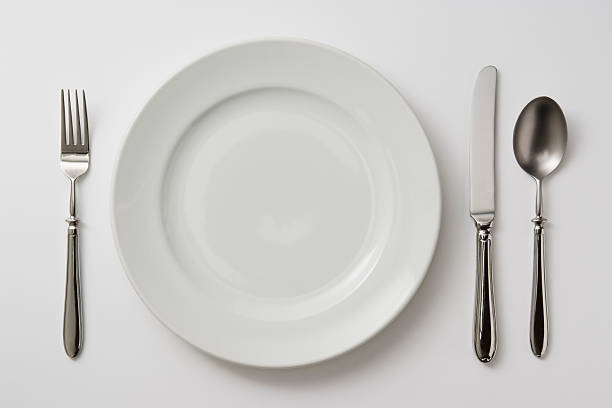 isolated shot of тарелки с столовые приборы на белом фоне - fork table knife silverware spoon стоковые фото и изображения