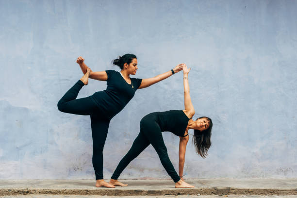 istock Two latins practicing yoga in the street during the day. 1830389754