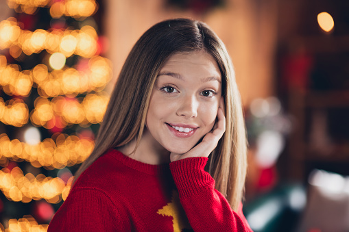 Closeup portrait of happy teenager cute girl touch cheek smiling xmas vibes pleasure at home during new year party isolated indoors.