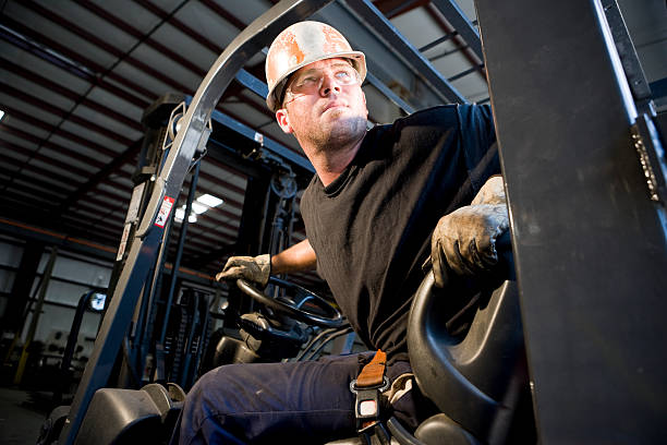 Male worker operating forklift in warehouse