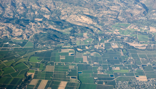 Aerial view of rolling landscape and farmland in an arid area. California.