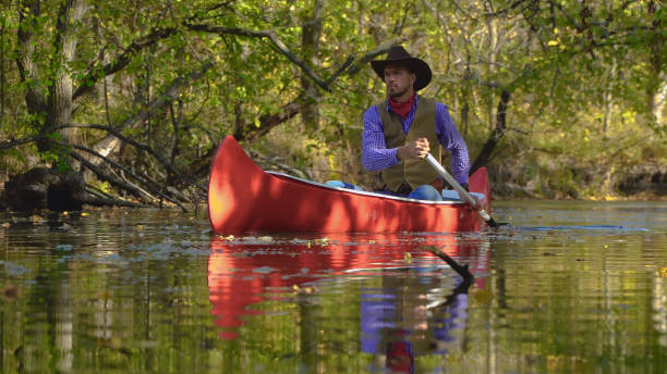 istock Cowboy in a canoe floats on the river in the forest 1830395729