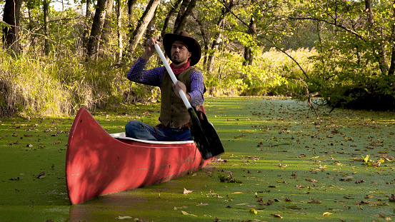 Vaquero en una canoa flota en el río photo