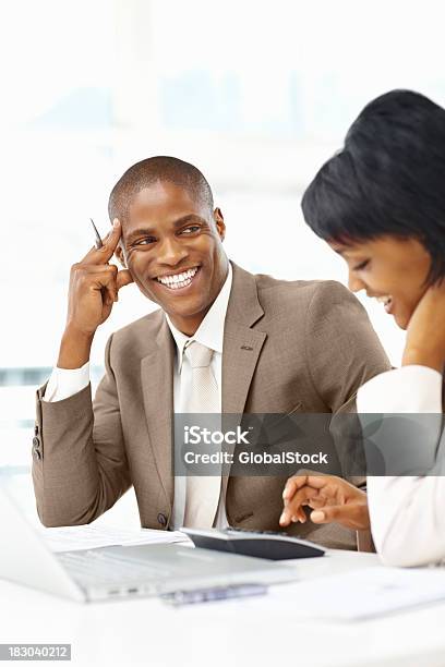 Foto de Feliz Homem De Negócios Trabalhando Com Uma Mulher No Escritório e mais fotos de stock de Discussão