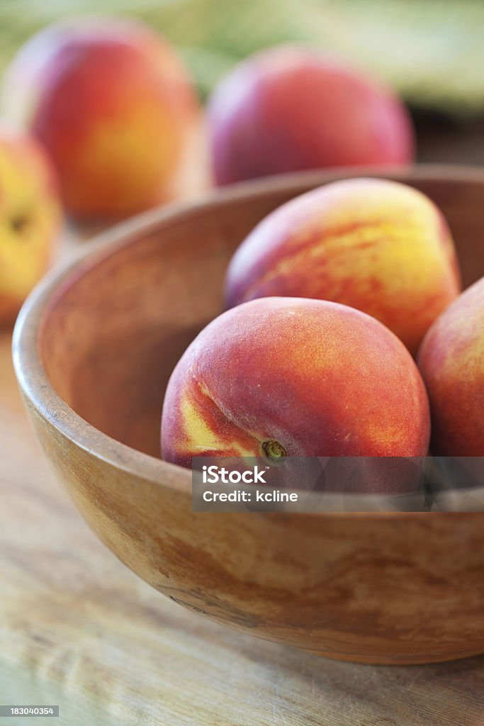Peaches A rustic wooden bowl filled with juicy organic peaches.  Shallow dof Bowl Stock Photo
