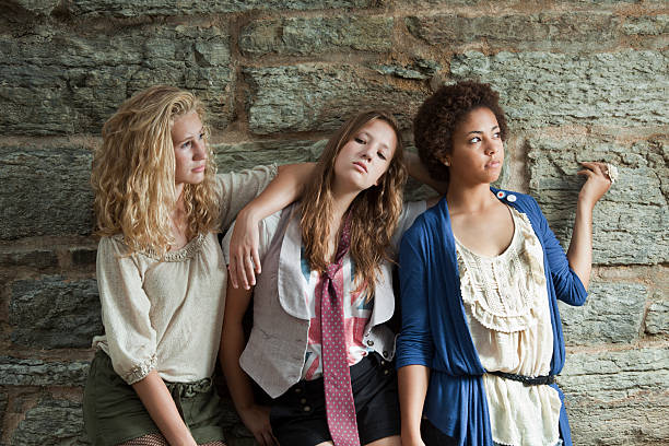 istock Young Women: Three Teenage Girls Looking Cool by Stone Wall 183040929
