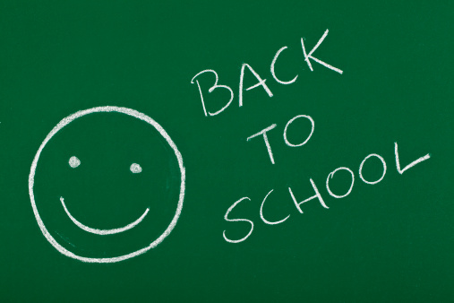 smiley with back to school message on blackboard