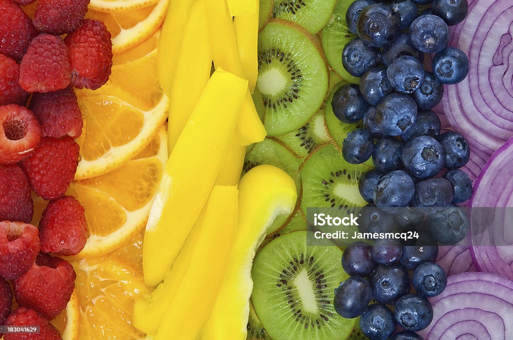 Colorful fruits and vegetables arranged in rainbow "Raspberries, Orange Slices, Yellow Bell Pepper, Kiwi Slices, Blueberries, and Red Onion arranged in a rainbow." Fruit Stock Photo