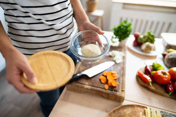 istock Unrecognizable woman using glass container to store vegetable leftovers 1830420733
