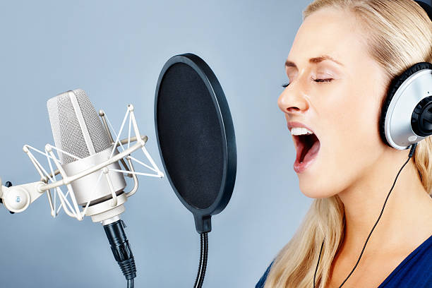 istock Pretty young woman with microphone singing a song 183042208