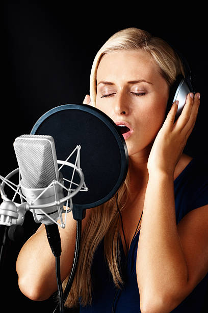 istock Young confident woman singing with a microphone 183042209