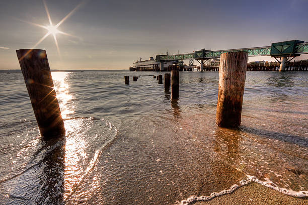 Pier, Ferry, and Beach An old pier goes to the water on the beach of edmonds washington with the ferry in the background. edmonds stock pictures, royalty-free photos & images