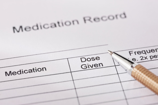 A pen is lying on top of a medication record form used for charting a patient's medication usage. Horizontal shot.