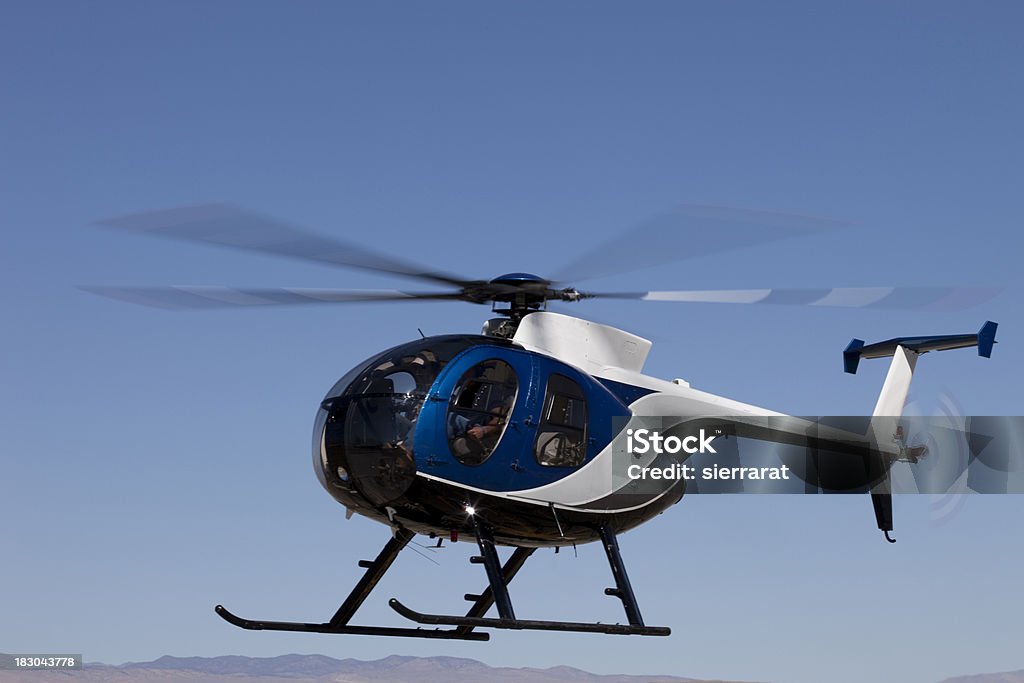 Huges 500 Helicopter Huges 500 Helicopter shot with slow shutter speed gives obvious rotor motion. Blue Stock Photo