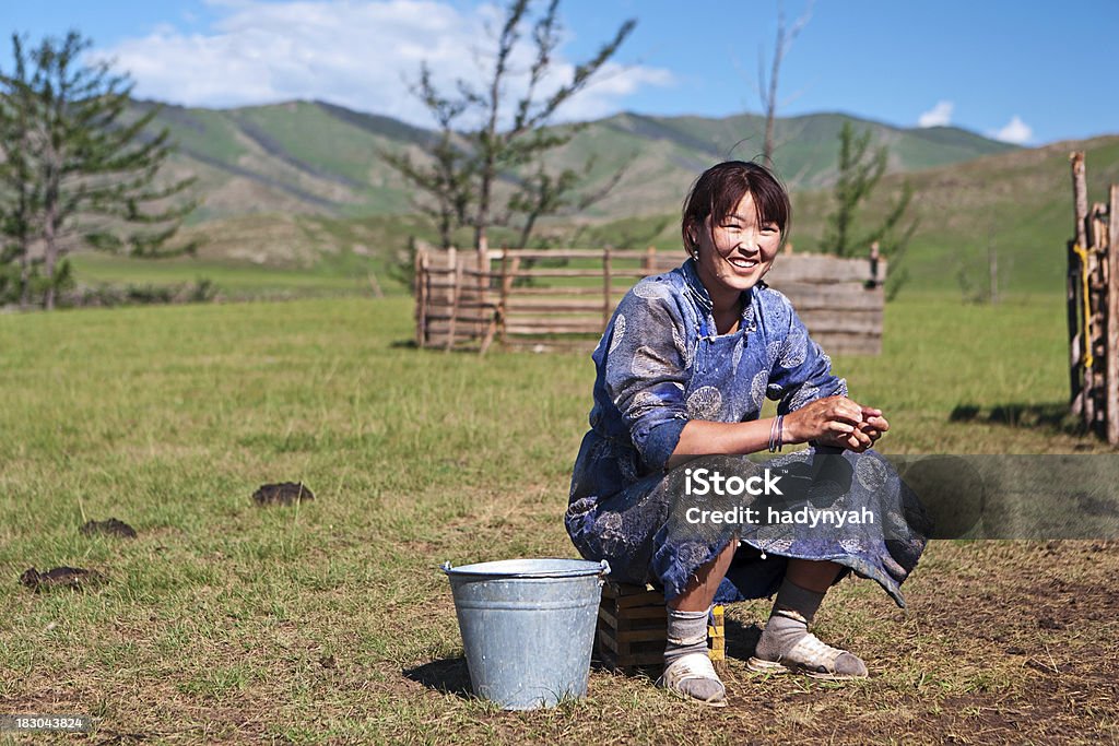 Mongolian woman in national clothing milking a yak Mongolian woman in national clothing milking a yak, Central Mongolia.http://bem.2be.pl/IS/mongolia_380.jpg Independent Mongolia Stock Photo