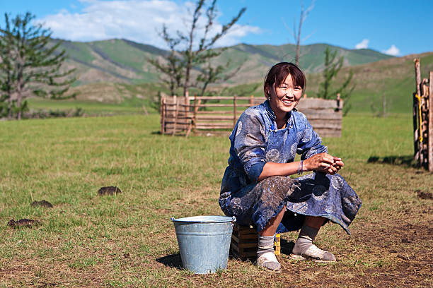 Mongolian woman in national clothing milking a yak Mongolian woman in national clothing milking a yak, Central Mongolia.http://bem.2be.pl/IS/mongolia_380.jpg mongolian ethnicity stock pictures, royalty-free photos & images