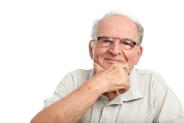 Head and shoulders portrait of happy grandfather wearing gray polo-shirt  and spectacles, hand on chin isolated on white.