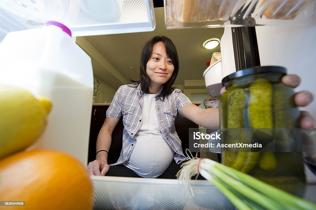 Pickle Craving Pregnant woman reaching for a jar of pickles inside a refrigerator Pickle Stock Photo
