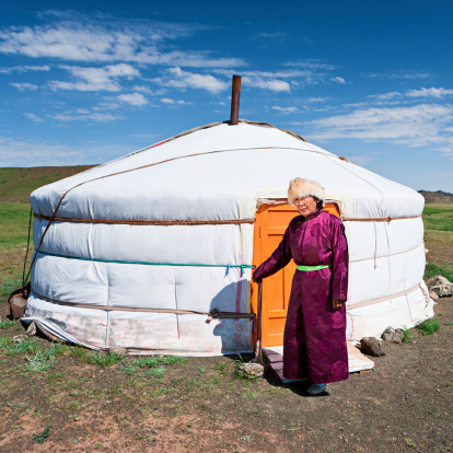 Mongolian woman in national clothing, ger (yurt) in the background.http://bem.2be.pl/IS/mongolia_380.jpg