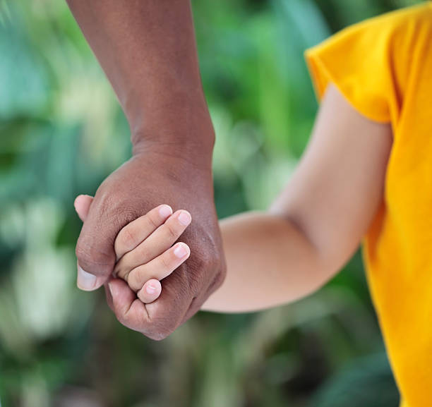 Father and child holding hands stock photo