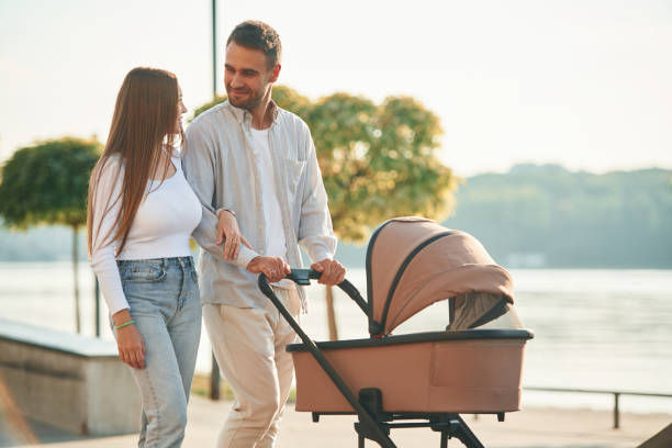 istock Weekend walk. A young couple with a baby pram are together 1830461321
