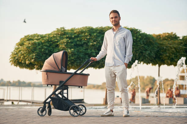 istock Young father is outdoors, standing with pram 1830462386