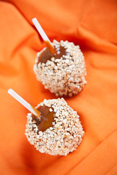 concept unhealthy eating: carmel apples covered in nuts
