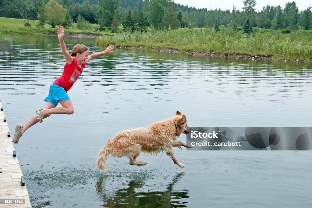Girl Swimming With Her Dog Happy child playing outdoors in summer. Dog Stock Photo