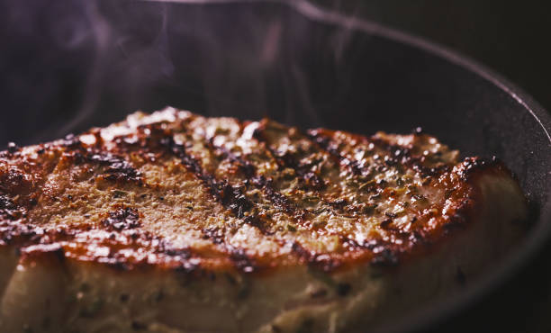 istock Seasoned tomahawk steak is cooked in a frying pan. 1830466643