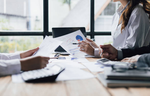 istock Business advisory meeting discussing analyzing company growth using business reports and financial charts. Brainstorming, analyzing strategies and planning investments. 1830471825