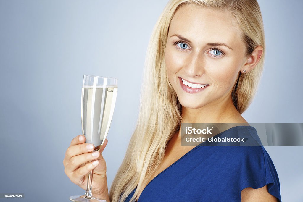 Beautiful young lady smiling and holding a glass of champagne Closeup portrait of a pretty young woman smiling and holding a glass of champagne 20-29 Years Stock Photo