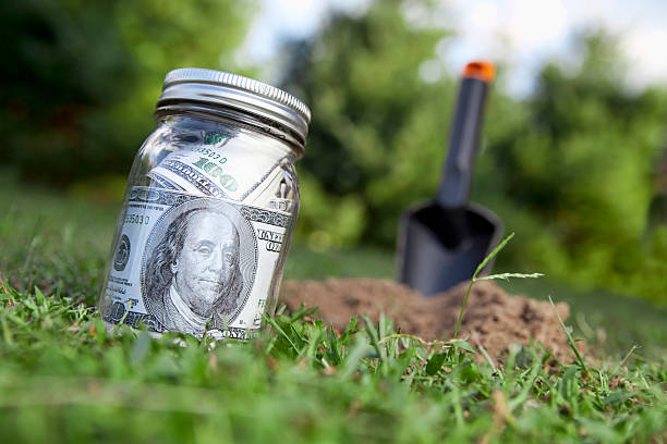 hole in ground Life savings ready to to be buried in the back yard. burying stock pictures, royalty-free photos & images