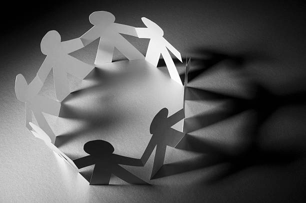 istock Circle of paper chain people holding hands in spotlight 183047506