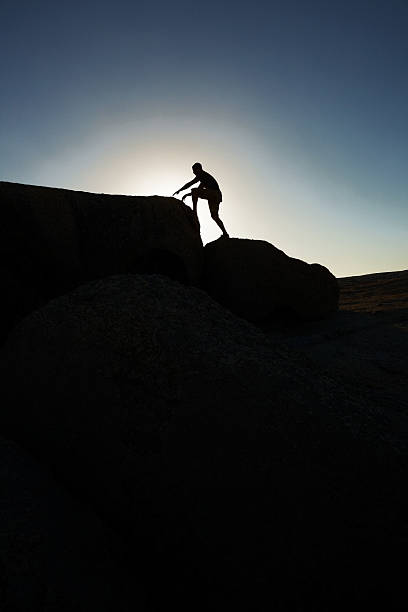 istock Silhouette image of one guy climbing a rock 183047628