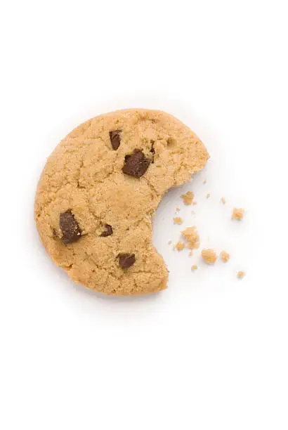 A studio shot of a biscuit with a bite taken out and crumbs, shot from above and isolated on a white background. The shape of the bite is in the shape of a mouth eating the crumbs