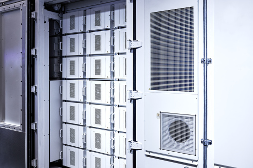 Side view of white lithium-ion battery modules at battery storage switchgear.
