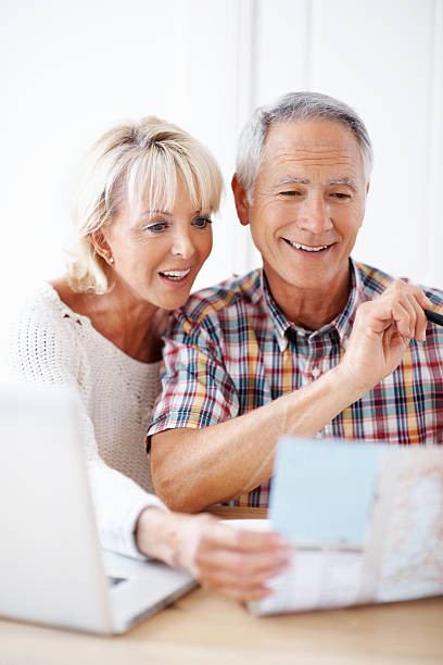 istock Mature couple planning their vacation with map and laptop 183048909