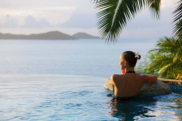 woman in a infinity pool hot tub at the resort spa beautiful woman in a infinity pool hot tub at the Caribbean resort spa infinity pool stock pictures, royalty-free photos & images