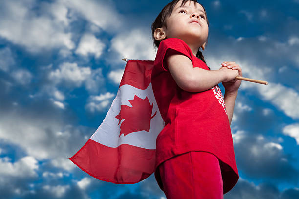 Canada Day 5 years old girl holding canadian flag canada flag blue sky clouds stock pictures, royalty-free photos & images