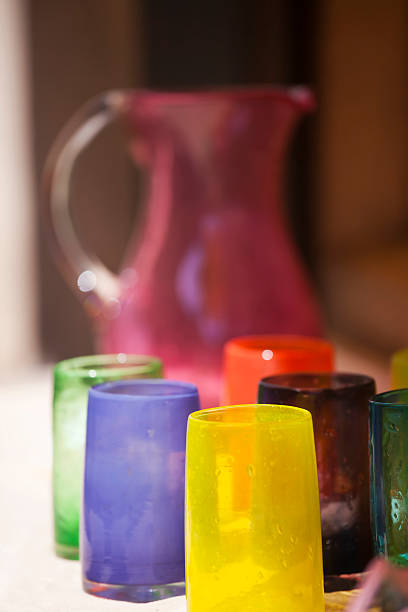 Hand Crafted Glassware "Handmade coloured  glass tumblers and water jug, hand made by crafsmen, for sale in the renown glassmaking village of Biot, near Cannes, in Provence, Southern France." biot stock pictures, royalty-free photos & images