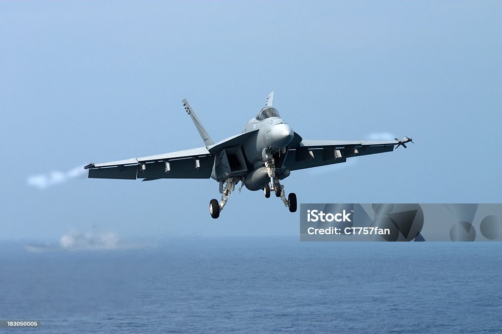 A fighter jet in the air over the sea A naval fighter plane on approach for landing. Navy Stock Photo