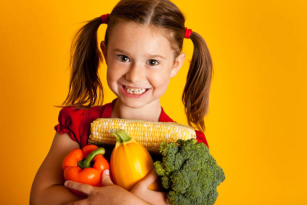istock Happy Girl Holding Vegetables, Bell Peppers, Broccoli, Squash, Corn 183050104