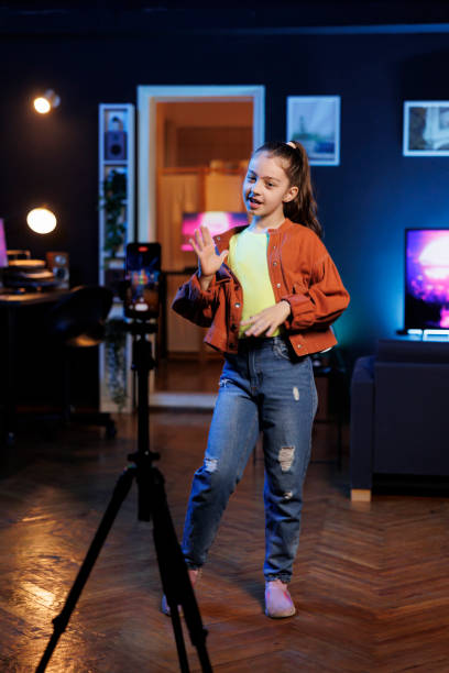 istock Child doing content creation for children, utilizing smartphone on tripod to produce dance videos 1830502326
